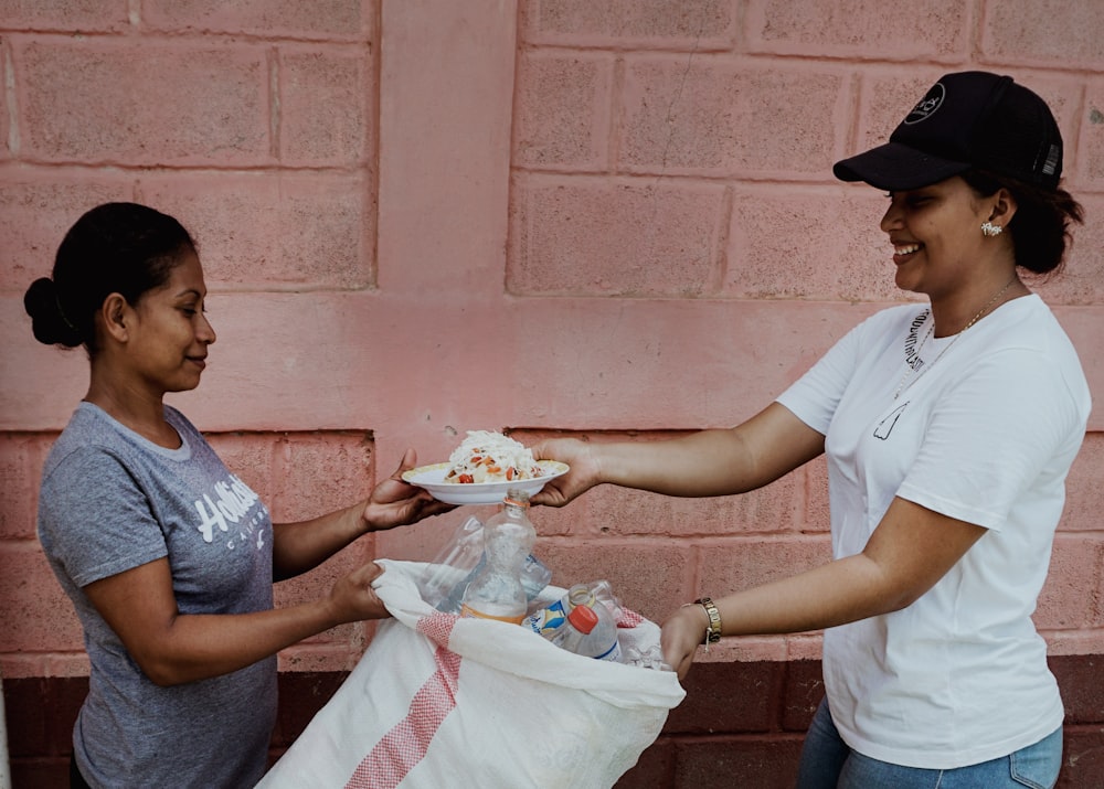 A volunteer handing a plate of food to a community member